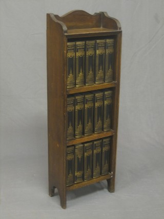 A 1920's oak 3 tier bookcase together with a  Britannia set of The Works of Dicken's contained therein 12"
