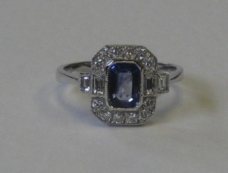 A lady's 18ct white gold dress ring set a rectangular cut sapphire and 2 baguette cut diamonds to the shoulders supported by numerous diamonds approx. 0.40/0.90ct