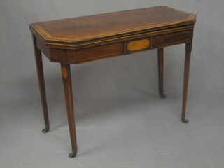 A 19th Century inlaid mahogany lozenge shaped card table raised on square tapering supports ending in brass caps and castors 37" (top smiling)  