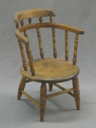 A child's elm spindle back chair with solid seat, raised on turned supports