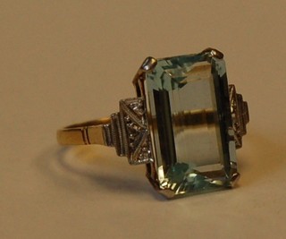 A gold dress ring set a rectangular aquamarine and with diamonds to the shoulders