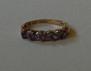A lady's 9ct gold dress ring set 5 amethysts supported by diamonds