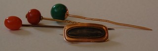 A gilt metal mourning brooch, 2 coral stick pins and a "turquoise" stick pin