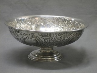 A circular embossed silver plated bowl raised on a spreading foot 11"