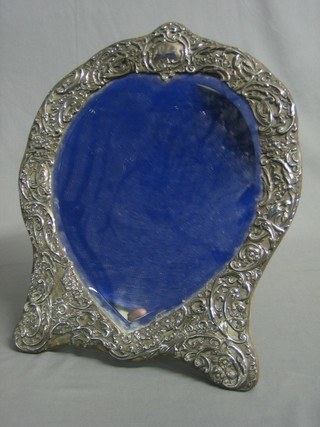 An Edwardian heart shaped bevelled plate easel mirror contained in an embossed silver frame, London 1905, makers mark WC 17"