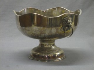A circular silver plated twin handled bowl with lion mask handles, raised on a spreading foot 10"