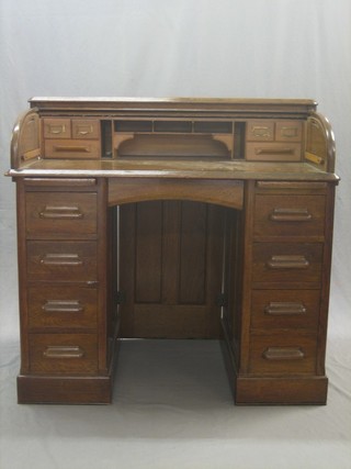 A Victorian honey oak roll top pedestal desk with well fitted interior, the base fitted 2 brushing slides above 8 short drawers 42" (tambour requires some attention)