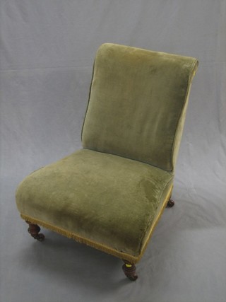 A Victorian walnut framed nursing chair upholstered in green material