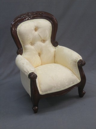 A Victorian style show frame mahogany child's armchair upholstered in green and raised on cabriole supports 