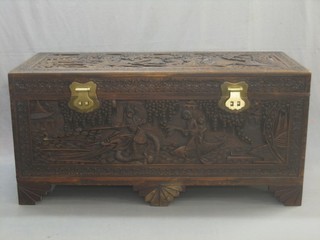 A 20th Century heavily carved camphor wood coffer with hinged lid, raised on bracket feet 50"