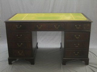 A mahogany kneehole pedestal desk with inset green leather writing surface above 1 long and 8 short drawers 54"