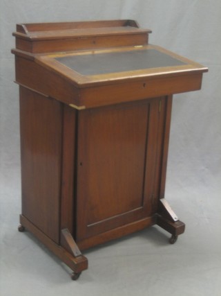 An Edwardian walnut Davenport the top with hinged stationery box, the pedestal fitted a cupboard enclosed by a panelled door 21"
