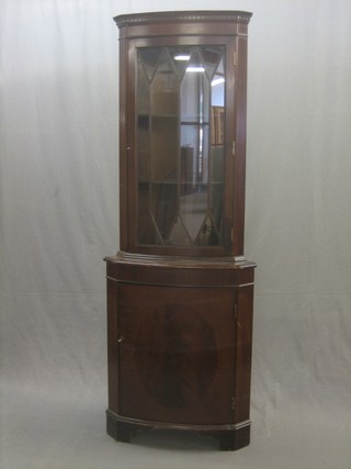 A Georgian style mahogany bow front double corner cabinet with moulded dentil cornice, fitted adjustable shelves enclosed by astragal glazed panelled doors, the base fitted a cupboard enclosed by panelled doors 23"