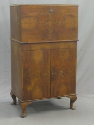 A walnut cocktail cabinet with hinged lid, the base fitted a cupboard enclosed by double doors 23"