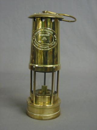 A miner's safety lamp by E Thomas & Williams contained in a brass case