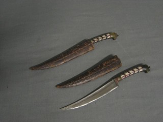 A pair of Eastern daggers with 4 1/2" shaped blades and horn grips