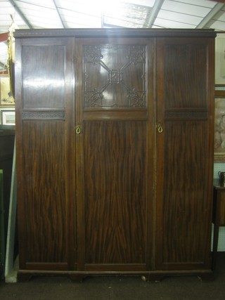 An Edwardian mahogany triple wardrobe enclosed by panelled doors by Maples 61"