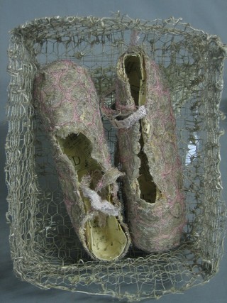 A pair of papiermache slippers contained in a wire work  box