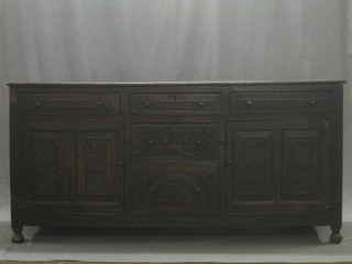 An 18th Century carved oak dresser base fitted 3 long drawers to the top, 2 to the centre and flanked by a pair of double cupboards 71"
