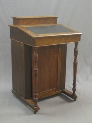 An Edwardian walnut Davenport with hinged stationery box, the pedestal fitted a cupboard and raised on turned supports 21"