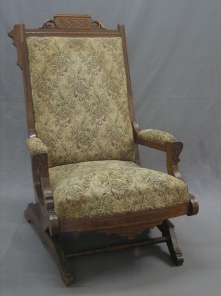 An American Victorian carved walnut show frame rocking chair