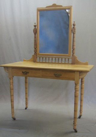 A Victorian pine dressing table with mirror over and bobbin turned decoration, the base fitted 2 drawers raised on turned supports 44"