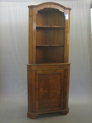 A Queen Anne style walnut and oak double corner cabinet, the domed upper section fitted shelves, the base fitted a cupboard enclosed by a panelled door raised on bracket feet 30"