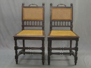 A pair of Continental oak hall chairs with woven cane seats and backs raised on turned and fluted supports