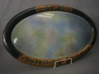 An oval bevelled plate wall mirror contained in a lacquered frame 31"