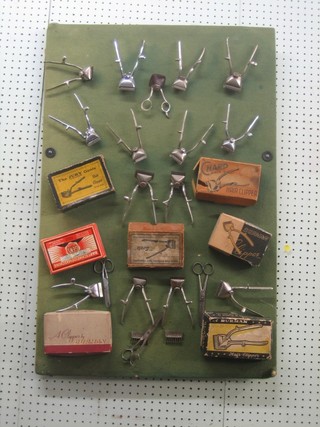A good collection of 1930's hair clippers mounted on a display board