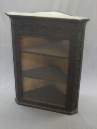 A carved oak corner cabinet, the interior fitted adjustable shelves 13"