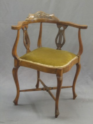 A carved walnut corner chair with lyre shaped slat back, raised on cabriole supports
