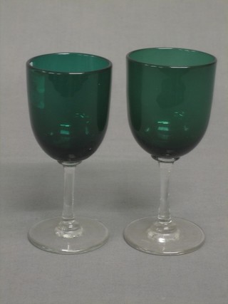 A pair of 19th Century green glass wine glasses with clear glass stems