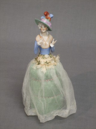 A porcelain headed pin cushion in the form of a crinoline lady 8"