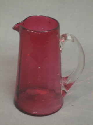 A Victorian cranberry glass jug with clear glass handle 7"