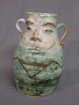 A large heavy Art Pottery green glazed twin handled vase decorated a face 15"