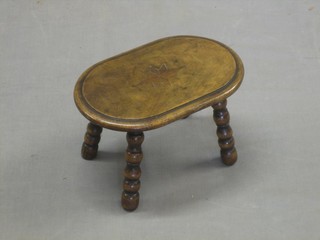 A Victorian oval inlaid walnut stool raised on bobbin turned supports 11"
