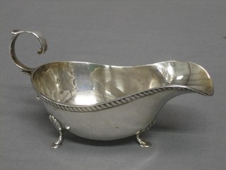 A silver sauce boat with C scroll handle, raised on 3 cabriole feet, marks rubbed 4 ozs
