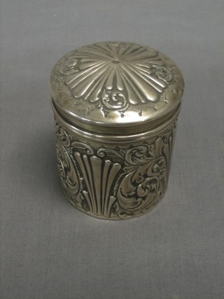 A Victorian cylindrical embossed silver jar and cover Birmingham 1887 4 ozs