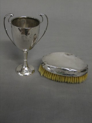 An Edwardian silver backed Military hairbrush, London 1906 together with a silver twin handled trophy cup Birmingham 1948