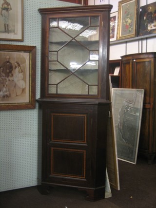 An Edwardian inlaid mahogany double corner cabinet, the upper section fitted shelves enclosed by an astragal glazed door, the base fitted a cupboard enclosed by a panelled door, raised on bracket feet 33"