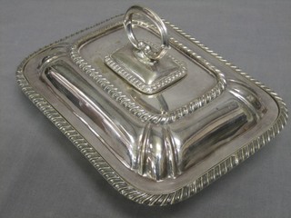 An oval silver plated entree dish and cover with bead work border