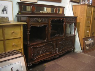 An Edwardian carved walnut sideboard with raised back fitted a cupboard enclosed by a glazed panelled door flanked by a pair of drawers beneath, the base fitted a double cupboard and on cabriole supports 60"