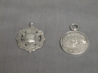 A silver News of The World watch chain medallion - My First Medal and 1 other watch chain medallion