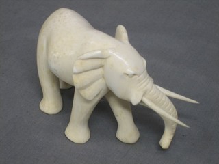 A carved ivory figure of a walking elephant 4"