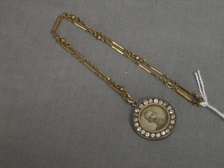 A gilt chain hung a gilt metal photo locket