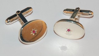 A pair of modern silver oval T bar cufflinks set rubies