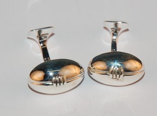 A pair of modern silver T bar cufflinks in the form of rugby balls