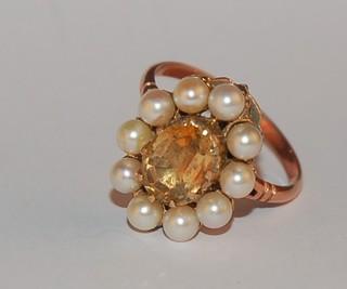 A lady's gold dress ring set an oval green coloured stone supported by pearls