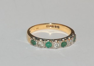 An 18ct gold half eternity ring set emeralds and diamonds